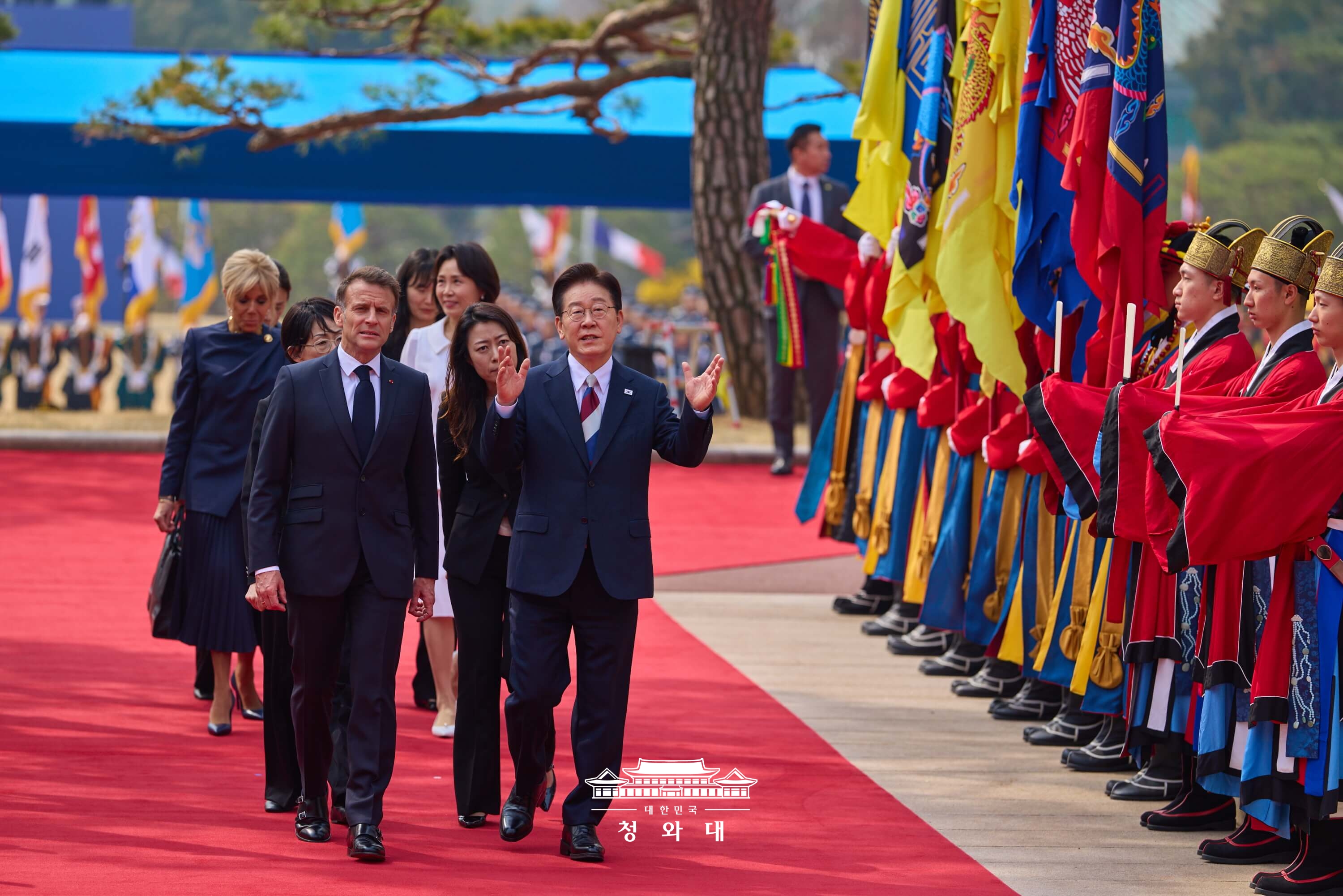  El presidente Lee Jae Myung (primero desde la derecha en la primera fila) y su homólogo francés, Emmanuel Macron, conversan mientras se desplazan hacia la ceremonia oficial de bienvenida de la visita de Estado a Corea, celebrada el 3 de abril en la oficina presidencial de Cheong Wa Dae, en el distrito de Jongno-gu, Seúl. | Cheong Wa Dae