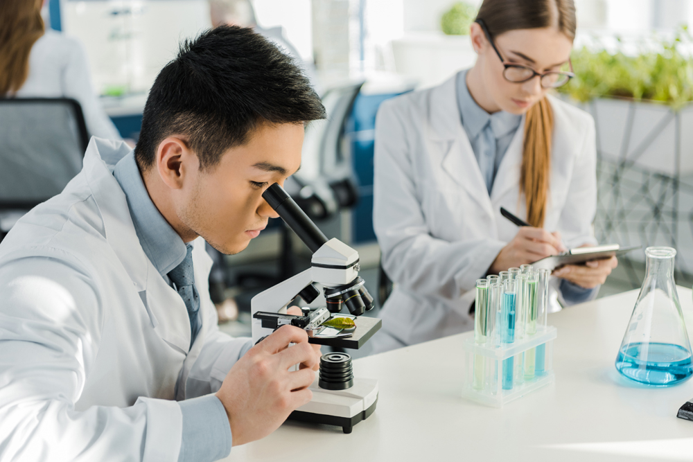  La foto muestra a dos investigadores observando unas muestras de laboratorio. | iClick Art (La reproducci&oacute;n o redistribuci&oacute;n no autorizada de esta imagen est&aacute; prohibida de acuerdo con las leyes de derechos de autor)