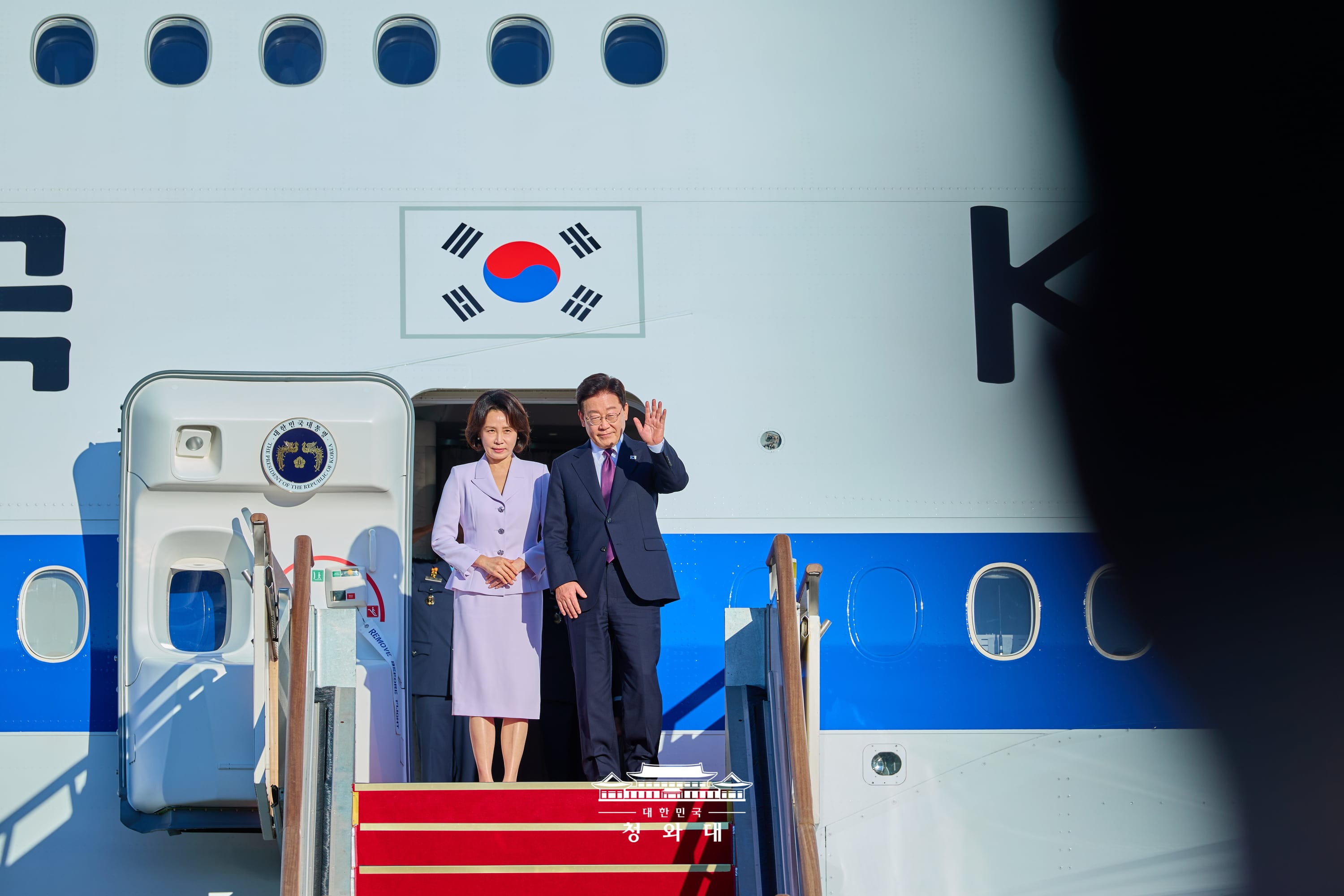 El presidente coreano Lee Jae Myung (dcha.) y la primera dama Kim Hea Kyung saludan a los asistentes antes de despegar el 21 de septiembre del aeropuerto de Se&uacute;l, en Seongnam, en la provincia de Gyeonggi-do,| Cheong Wa Dae