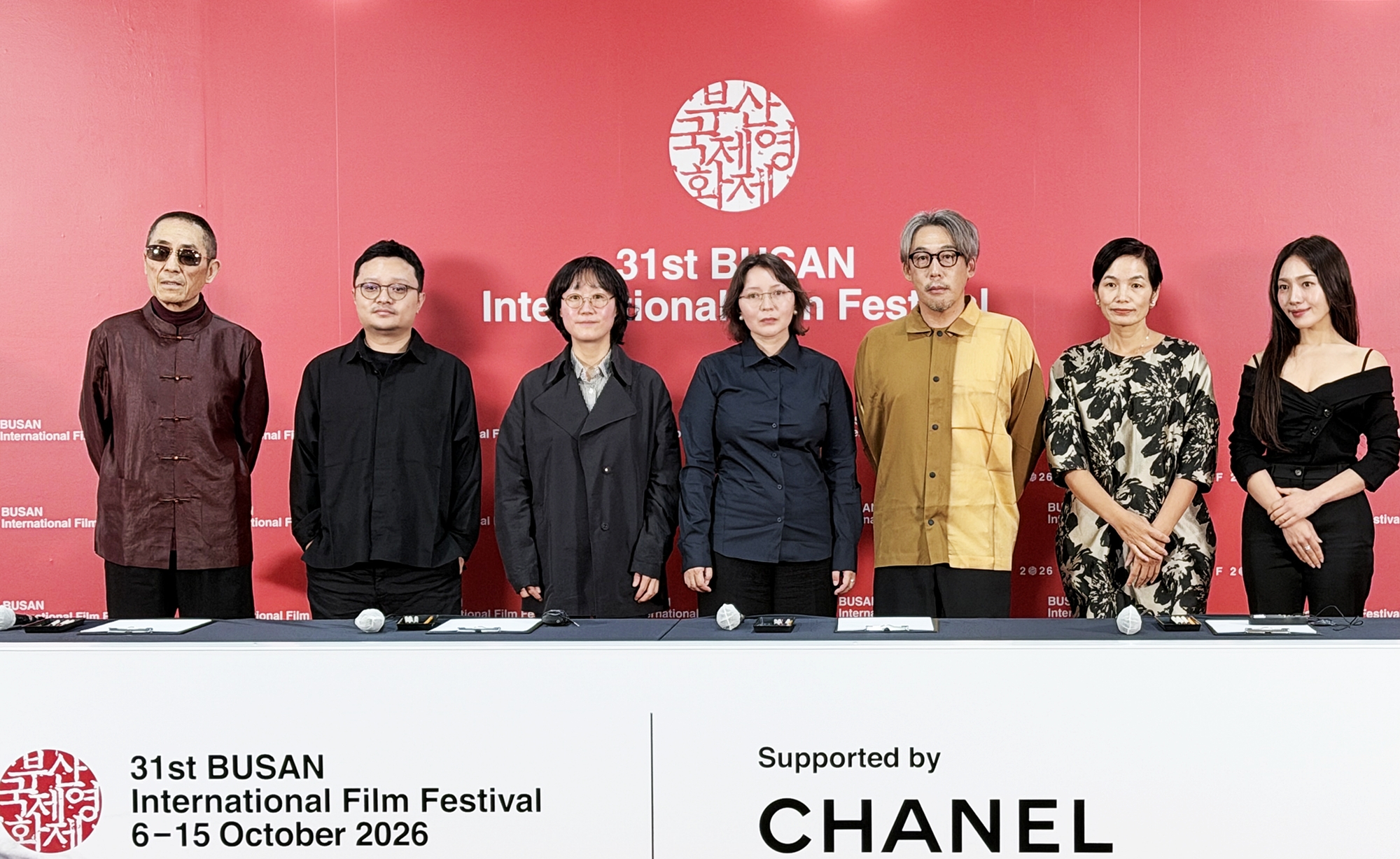 Los miembros del jurado de la secci&oacute;n competitiva posan ante los medios durante la rueda de prensa celebrada el 7 de octubre, en la segunda jornada de la 31&ordf; edici&oacute;n del Festival Internacional de Cine de Busan (BIFF, por sus siglas en ingl&eacute;s), en el Centro de Cine de Busan, en el distrito de Haeundae-gu. De izquierda a derecha: el presidente del jurado, Zhang Yimou; los directores Bi Gan y July Jung; la actriz Samal Samal Yeslyamova; los directores Ishikawa Kei y Tran Thi Bich Ngoc; y la actriz Moon Choi. | Xu Aiying 