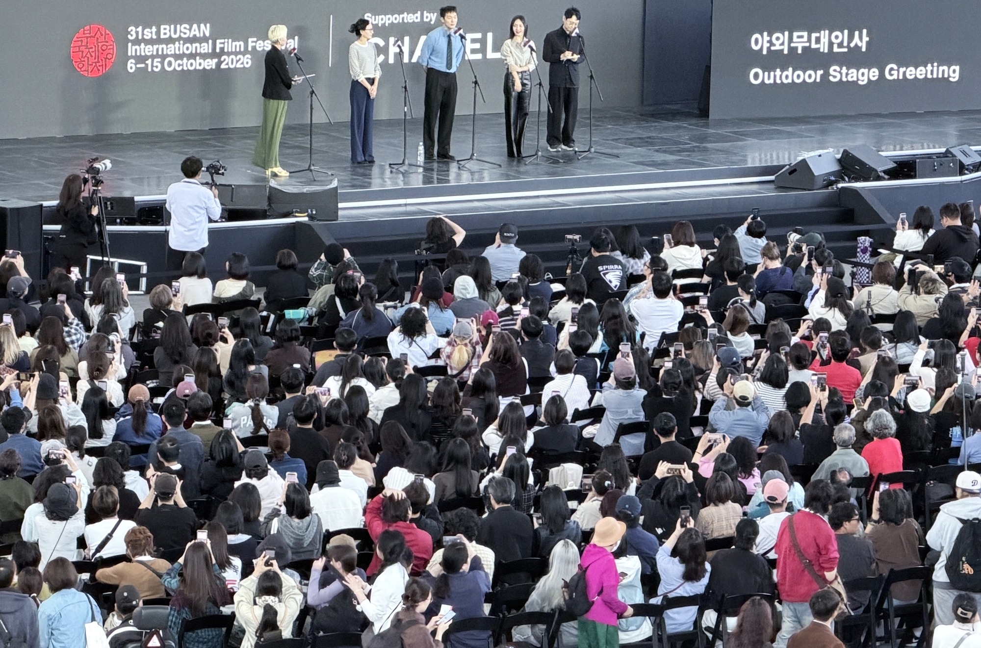El equipo de la pel&iacute;cula 'Bedford Park' saluda al p&uacute;blico desde el escenario exterior del Centro de Cine de Busan, en el distrito de Haeundae-gu, el 7 de octubre. | Xu Aiying