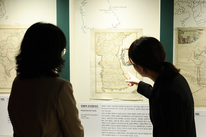 La curadora Kim Bo-young (derecha) comenta los detalles del mapa histórico 'Reino de Corea' (Royaume de Corée, 1735), del cartógrafo francés Jean-Baptiste Bourguignon d'Anville, durante una visita, el 16 de octubre, a la sala de exposiciones del Museo de Dokdo en Seúl .
