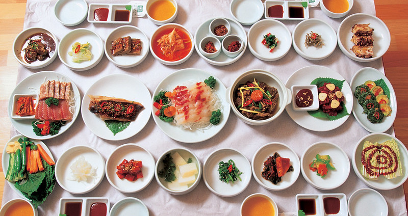 La foto muestra una mesa repleta de diversos platos tradicionales y guarniciones coreanas. | Korea.net DB