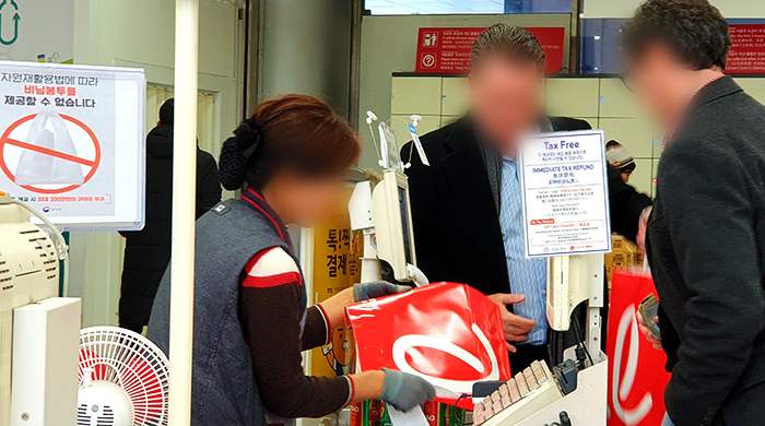 El 9 de enero dos extranjeros compran las bolsas de papel para cargar sus compras en Lotte Mart gracias a la prohibición de las bolsas de plástico en los supermercados y tiendas de abarrote.