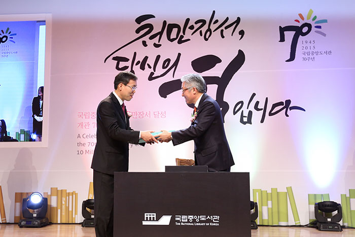 국립중앙도서관 천만장서 달성 및 개관 70주년 기념식에서 김종덕 문화체육관광부 장관(오른쪽)이 천만번째 장서를 임원선 국립중앙도서관장에게 건네고 있다. 