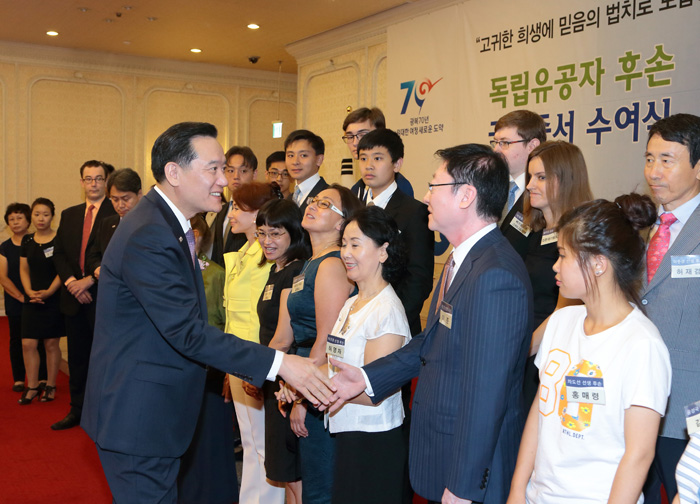 김현웅 법무부장관이 국적증서 수여식에 참석한 독립유공자 후손들과 악수하고 있다. 