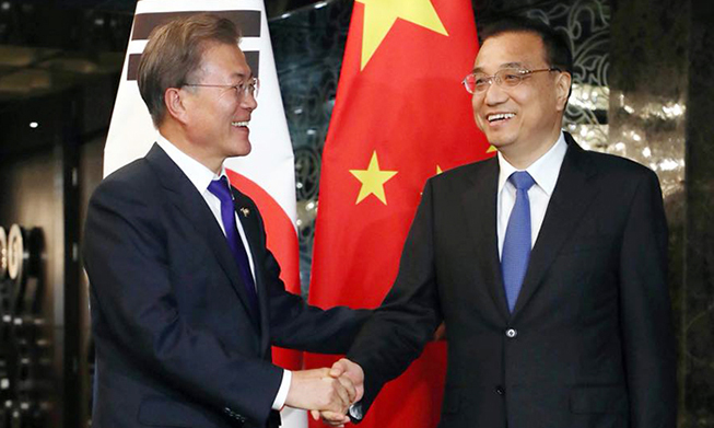 El presidente Moon conoce al primer ministro chino Li Keqiang