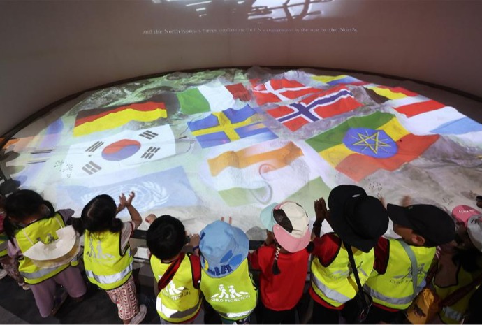 Unos niños visitan el Monumento a la 1ª Batalla de las Fuerzas de la ONU