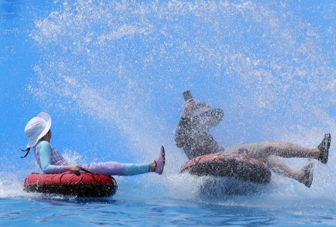 Los visitantes combaten el calor sobre trineos acuáticos