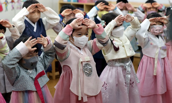 Niños aprendiendo a hacer el saludo de reverencia