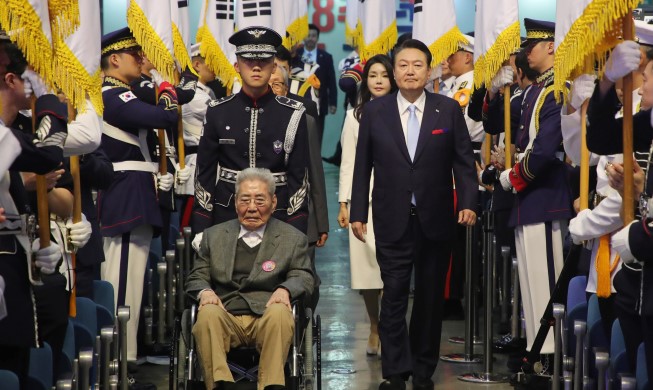 La pareja presidencial entra en la ceremonia del Día de la Liberación con un luchador por la independencia coreana