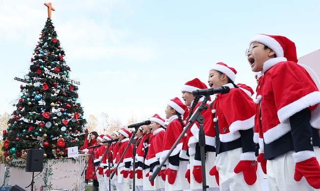 Coro de niños vestidos de Santa claus canta para la campaña benéfica