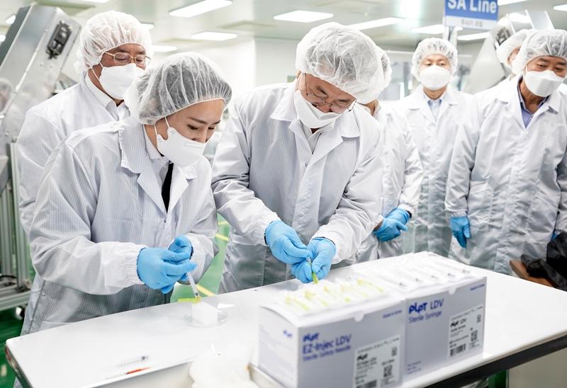 El presidente Moon Jae-in demuestra una jeringa de espacio muerto reducido durrante una visita a la fábrica de PoongLim Pharmatech Inc., en la ciudad de Gunsan, provincia de Jeollabuk-do. | Yonhap News
