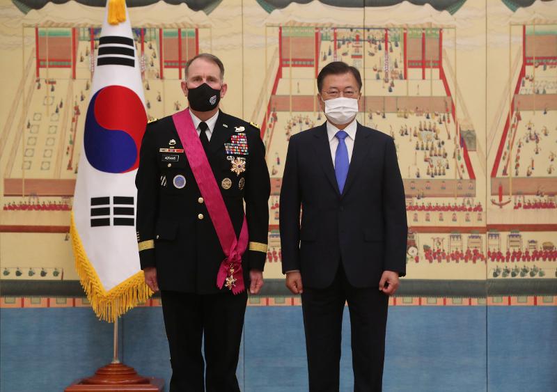 El 1 de julio, el presidente Moon Jae-in (dcha.) posa para una foto conmemorativa con el general Robert Abrams, comandante saliente de las Fueras Armadas Estadounidenses en Corea del Sur tras concederle un mérito importante de seguridad nacional en la oficina presidencial Cheong Wa Dae en Seúl. | Agencia de Noticias Yonhap