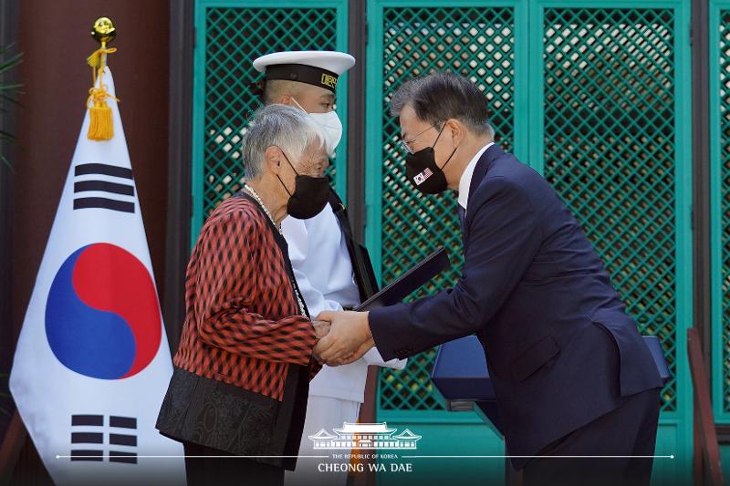  El presidente Moon Jae-in (dcha.), entrega una medalla de honor póstuma a una inmigrante coreana, descendiente del difunto activista por la independencia Kim No-di, durante una ceremonia de homenaje póstumo de entrega de la orden de mérito para los luchadores por la independencia, celebrada, el 22 de septiembre (hora local), en el Instituto de Estudios Coreanos de la Universidad de Hawái, Estados Unidos. | Agencia de Noticias Yonhap