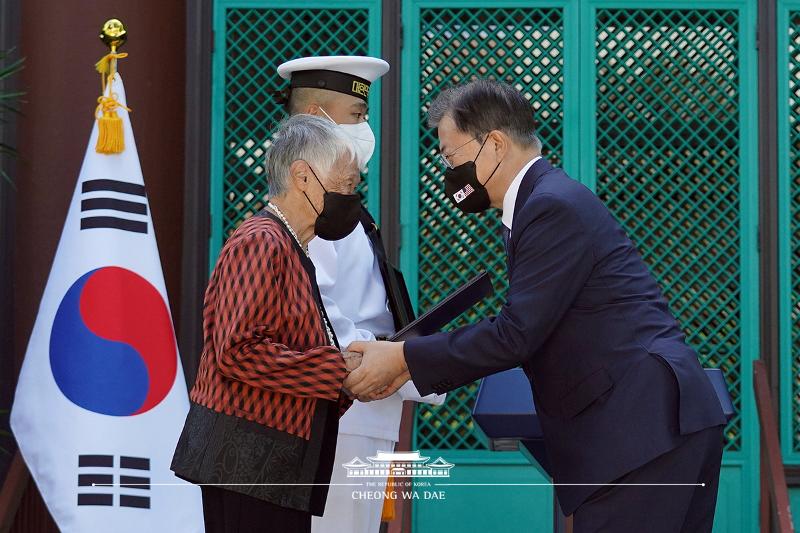 El presidente Moon Jae-in (dcha.), entrega una medalla de honor póstuma a una inmigrante coreana, descendiente de la difunta activista por la independencia Kim No-di, durante una ceremonia de homenaje póstumo de entrega de la orden de mérito para los luchadores por la independencia, celebrada el 22 de septiembre (hora local) en el Instituto de Estudios Coreanos de la Universidad de Hawái, Estados Unidos. Es la primera vez que un presidente surcoreano otorga medallas de honor a personas meritorias en el extranjero.