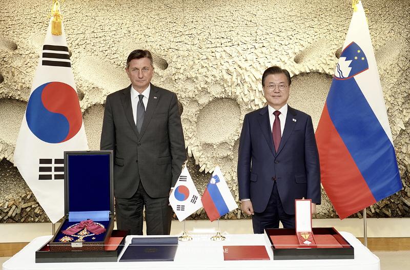 El presidente Moon Jae-in (dcha.) y su homólogo esloveno, Borut Pahor, posan ante la cámara, el 20 de septiembre (hora local), frente a las respectivas medallas que se confirieron por sus esfuerzos para los avances en sus relaciones bilaterales, durante su cumbre celebrada en Nueva York.
