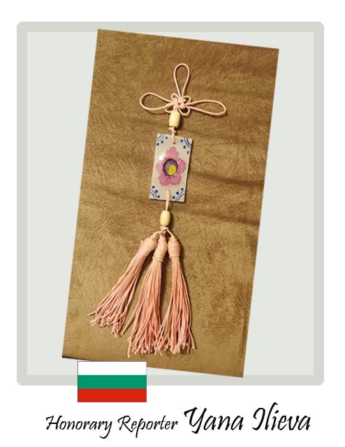 La reportera honoraria Yana Ilieva de Bulgaria quedó impresionada cuando supo que todos los nudos en el norigae tienen un significado especial, en el que ella realizó, incluyó el nudo llamado Dongsimgyeul que significa 'nudo de amantes', y decidió combinarlo con un elemento plástico de Rose Sharon, la flor nacional coreana. | Yana Ilieva