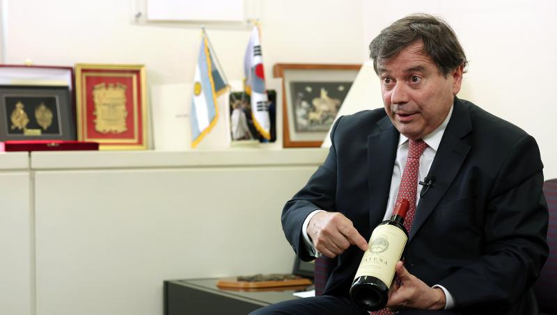 El embajador argentino en Corea, Alfredo Carlos Bascou, presenta un vino argentino durante la entrevista del 17 de mayo con Korea.net. Dijo que Catena, el vino que sostenía, solo se puede encontrar en la Embajada Argentina en Corea, siendo el logo en la botella el emblema nacional oficial del país latinoamericano. 