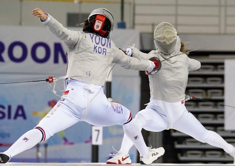 La esgrimadora surcoreana de esgrima femenina Yoon Ji-soo (izquierda) compite el 15 de junio con su contraparte japonesa en la final de sable femenino en equipos en el Campeonato Asiático de 2022 celebrado en el Estadio de Esgrima del Parque Olímpico en el distrito de Songpa-gu, Seúl.