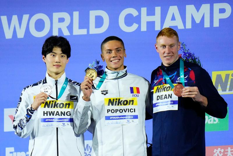 Hwang Sun-woo (izquierda) el 20 de junio posa para una foto en la ceremonia de entrega de premios después de reclamar la medalla de plata en los 200 metros estilo libre masculino en el Campeonato Mundial de Natación de este año, junto con el medallista de oro David Popovici de Rumanía (centro) y el medallista de bronce Tom Dean del Reino Unido. | Agencia de Noticias Yonhap 