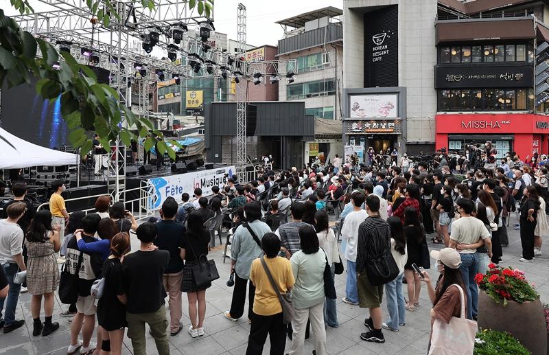 Los ciudadanos disfrutan de un espectáculo callejero en el 'Festival de Música Callejera de Francia' celebrado en Yonsei-ro, en el barrio de Sinchon-dong, en el distrito de Seodaemun-gu en Seúl el pasado 19 de junio.