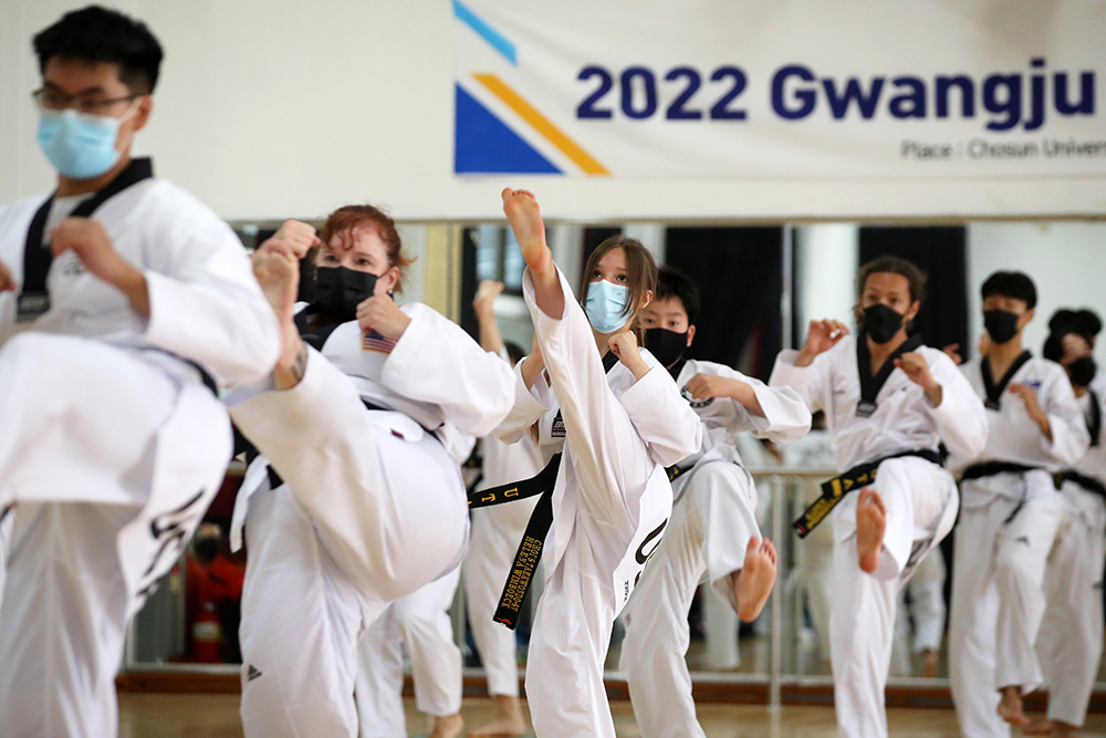 Practicantes extranjeros de taekwondo, el 19 de julio, realizan poomsae (posturas) en la 'Academia Internacional de Taekwondo de Gwangju 2022'