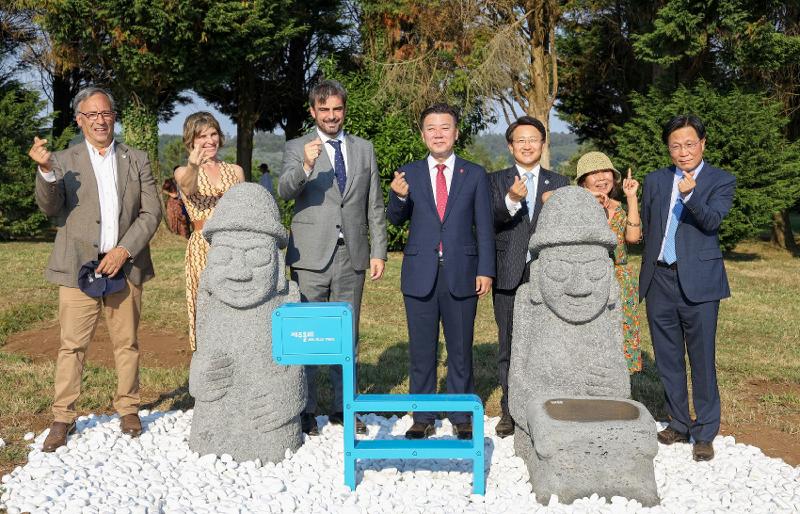  El 12 de julio, funcionarios de la isla de Jeju y de la comunidad autónoma española de Galicia posan para una foto conmemorativa en la ceremonia de inauguración de dolhareubang, o una gran estatua de roca típica de Jeju con figura de un abuelo, y ganse, una escultura azul con forma de potro que es el símbolo del sendero Jeju Olle Trail, en el Monte do Gozo en el tramo Arca del famoso Camino de Santiago. 