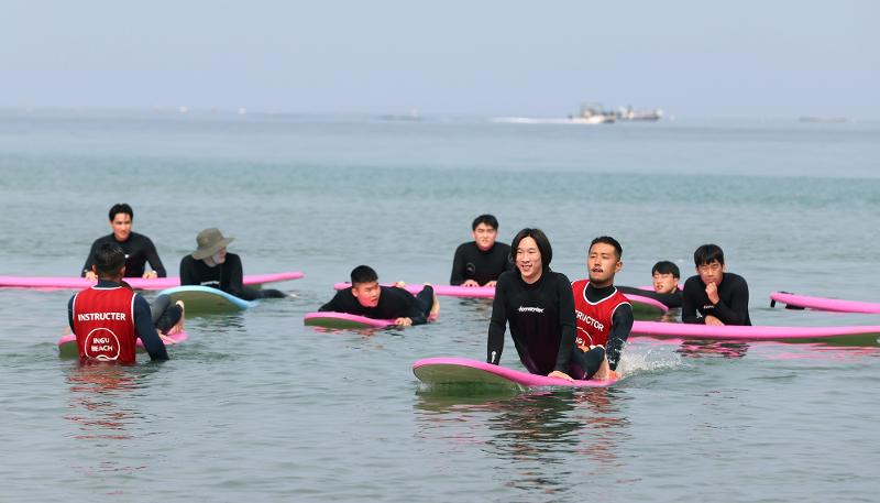 Los visitantes en la playa Ingu aprenden a surfear. | Lee Jun Young