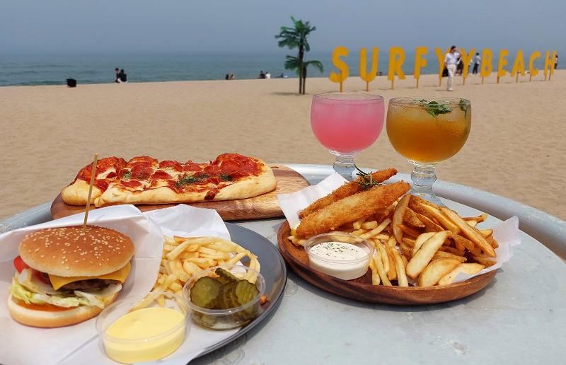 En los bares al atardecer de Surfyy Beach se ofrece una gran cantidad de platos como pizza, hamburguesas y pescado y papas fritas, así como cerveza y cócteles. | Anaïs Faure 