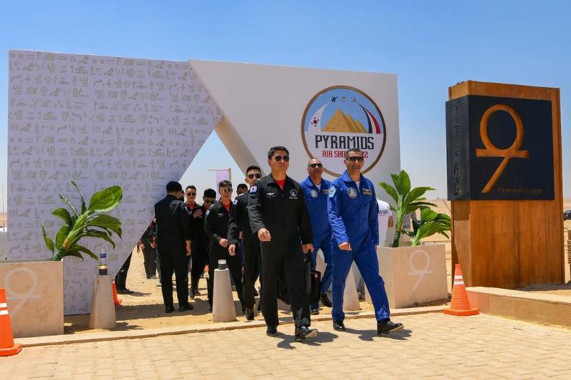 Los pilotos de los Black Eagles, el equipo de exhibición acrobática de la Fuerza Aérea de la República de Corea, y sus homólogos egipcios, de los Silver Stars, ingresan el 3 de agosto al sitio del Pyramid Air Show 2022 en El Cairo, Egipto