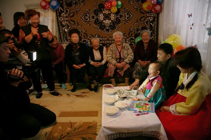 La foto, tomada el 2015, muestra una fiesta del primer cumpleaños de un bebé se lleva a cabo en el pueblo Soldatskoe en la provincia de Tashkent de Uzbekistán. Entre los rituales de Goryeoin, esa fiesta fue menos influenciada por Rusia u otros países vecinos. Cuando Corea formó lazos diplomáticos con Uzbekistán en 1992, se produjeron cambios como el uso de hanbok (vestimenta tradicional) como vestimenta ceremonial para la fiesta. | Museo Folclórico Nacional de Corea 