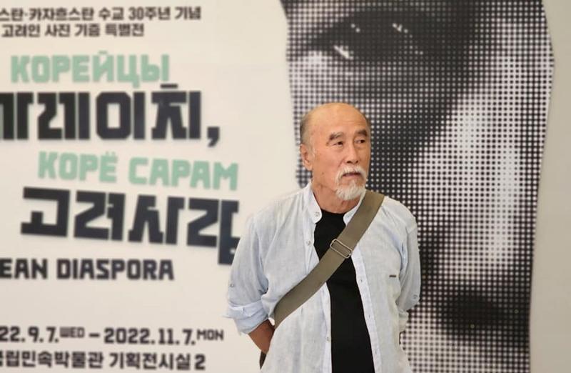 El fotógrafo coreano-uzbeko Viktor An posa frente al cartel promocional de su exposición 'La diáspora coreana' en el Museo Folclórico Nacional de Corea, en el distrito Jongno-gu de Seúl. | Media Saram