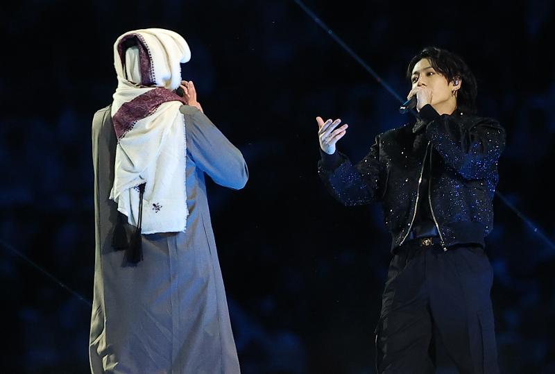 Jungkook (dcha.), integrante del grupo de K-pop BTS, realiza una actuación con el cantante catarí Fahad Al-Kubaisi en la ceremonia de inauguración de la Copa Mundial de la FIFA 2022, celebrada, el 20 de noviembre (hora local), en el estadio Al Bayt, en la municipalidad de Jor, Catar. 