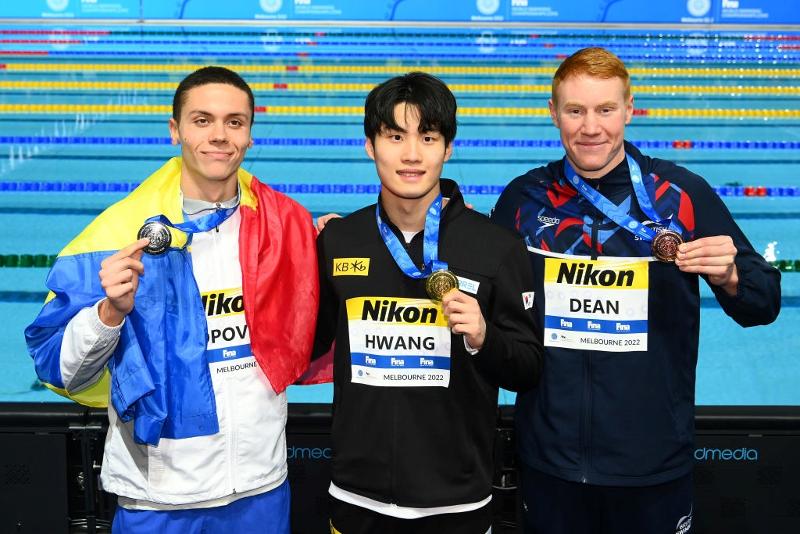 Hwang Sun-woo (centro) posa el 18 de diciembre en la ceremonia de entrega de medallas después de ganar el oro en los 200 m estilo libre masculino en el Campeonato Mundial de Natación en Piscina Corta de la FINA en Melbourne, Australia, junto con el subcampeón David Popovici de Rumania (izquierda) y el medallista de bronce Tom Dean del Reino Unido.