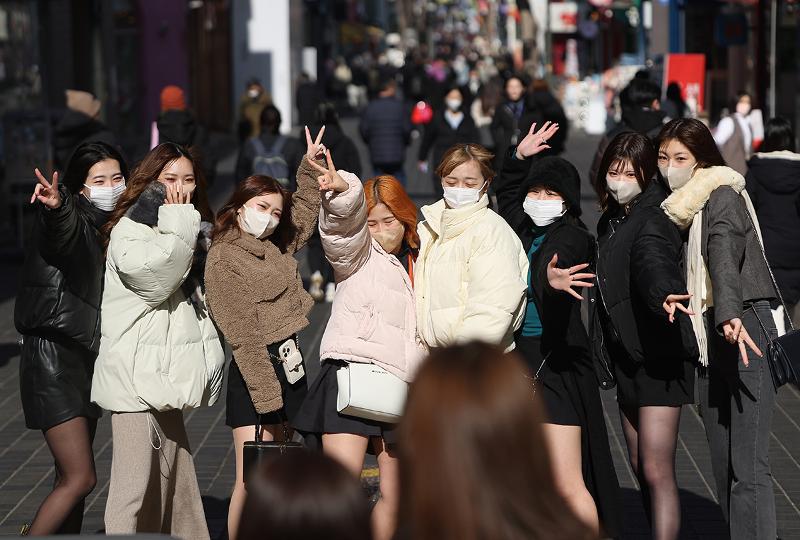 El 8 de febrero, turistas japonesas se toman fotos en las calles de Myeong-dong en el distrito de Jung-gu en Seúl. | Agencia de Noticias Yonhap