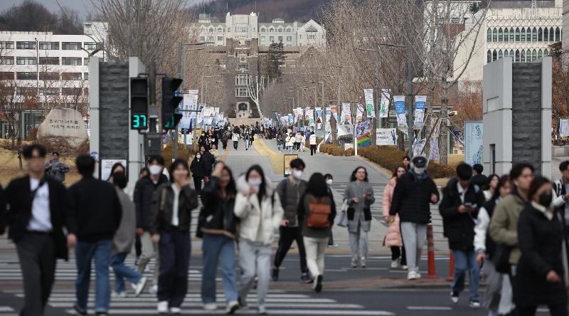 Unos estudiantes caminan por la puerta principal de la Universidad de Yonsei en el distrito de Seodaemun-gu, Seúl, tras el comienzo del primer semestre de 2023. | Agencia de Noticias Yonhap