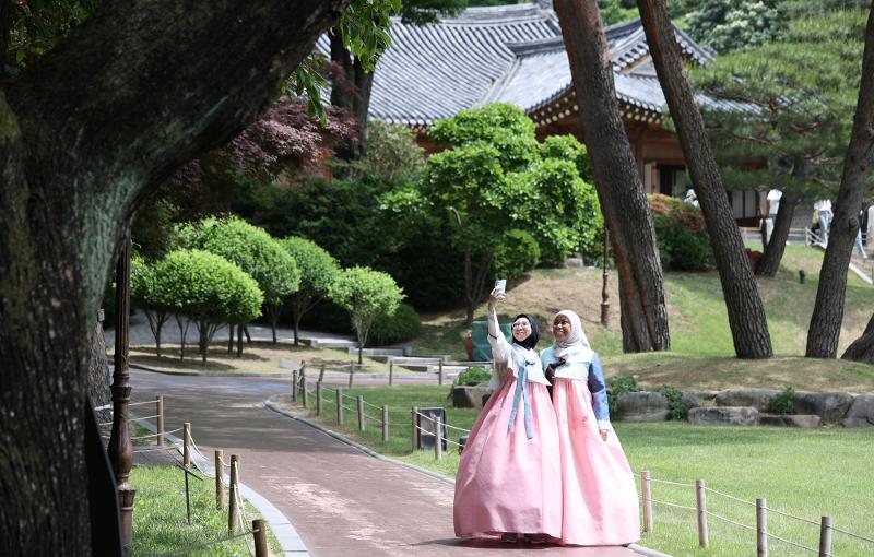 El 24 de mayo, dos turistas extranjeras que portan el hanbok, se toman una foto conmemorativa, mientras dan un paseo por Cheong Wa Dae, en el marco del Hanbok Experience Exhibition 2023, llevado a cabo en el distrito de Jongno-gu, Seúl.