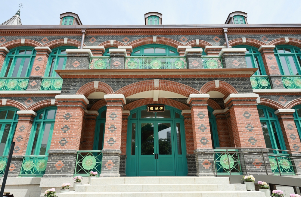El exterior del Dondeokjeon tras su reconstrucción. El edificio destaca por sus ladrillos rojos, los marcos azules de las ventanas y las balaustradas decoradas con flores de ciruelo, símbolo de la familia imperial.