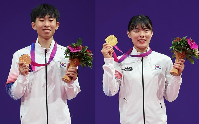 Kang Wan-jin (izda.) y Cha Yea-eun de Corea del Sur muestran el 24 de septiembre sus medallas de oro en las pruebas de taekwondo 'poomsae' individual masculino y femenino, respectivamente, en los XIX Juegos Asiáticos, durante una ceremonia de entrega de medallas, en el Centro Cultural Deportivo y de Exhibiciones de Lin'an, en Hangzhou, China.