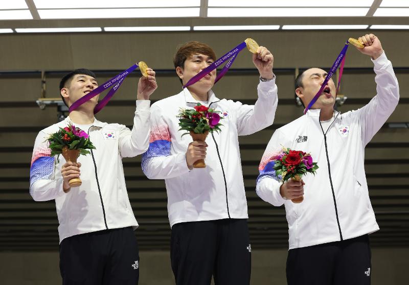 Kwak Yong-bin (izquierda), Jeong You-jin (centro) y Ha Kwang-chul, se toman una foto después de recibir la medalla de oro en la competencia de tiro al blanco móvil mixto a 10 metros por equipos, que se llevó a cabo el 26 de septiembre en el centro deportivo Fuyang Yinhu, en Hangzhou, China.