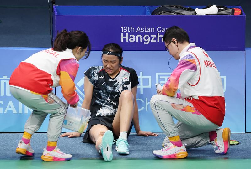 El 7 de octubre, An Se-young (centro) es atendida por dos paramédicos por una lesión en la rodilla derecha que experimentó mientras bloqueaba el ataque de la china Chen Yufei en la final de la prueba individual femenina, en el Gimnasio Binjiang, en Hangzhou, China. A pesar de recibir tratamiento médico y no tener una condición física estable, An mostró su poder al ganar el título.