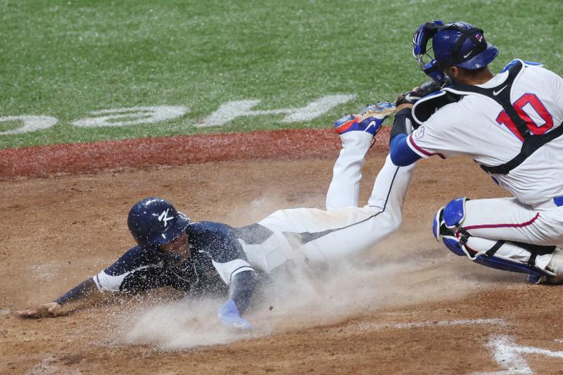 El 7 de octubre, el surcoreano Kim Joo-won vuela a la tercera base y anota a su compañero Moon Bo-kyong, durante la segunda entrada del partido de béisbol entre Corea del Sur y Taiwán, que se llevó a cabo en el Centro Deportivo de Béisbol y Softbol de Shaoxing en Hangzhou, China. El equipo surcoreano de béisbol derrotó a Taiwán, con un marcador 2-0.