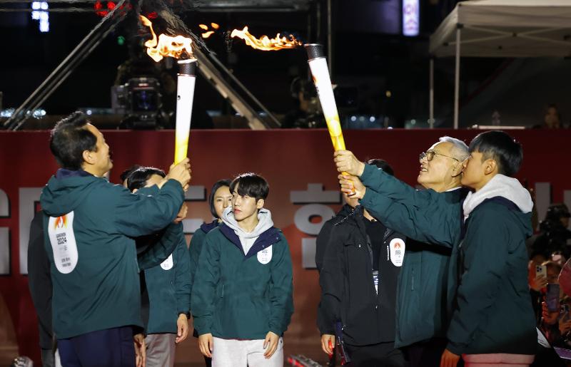 El 11 de octubre, el ministro de Cultura, Deportes y Turismo, Yu In-chon (2º desde la derecha), recibe la antorcha de manos del alcalde de Seúl, Oh Se-hoon, en la ceremonia del relevo de la antorcha de los Juegos Olímpicos de la Juventud de Invierno de Gangwon 2024, celebrada en la plaza de Seúl, en el distrito de Jung-gu.