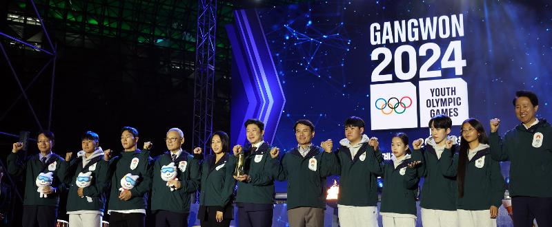 El 11 de octubre, el ministro de Cultura, Deportes y Turismo, Yu In-chon (4º desde la izquierda), y otros asistentes a la ceremonia de relevo de la antorcha de los Juegos Olímpicos de la Juventud de Invierno de Gangwon 2024 posan para una foto de grupo 100 días antes del comienzo de la competición en la plaza de Seúl, en el distrito capitalino de Jung-gu.