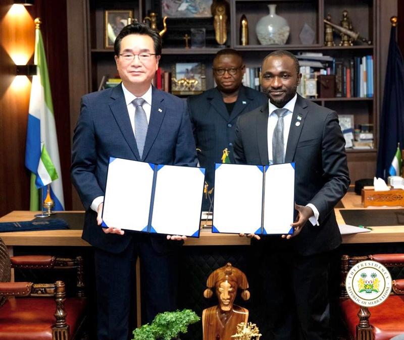 El ministro de Agricultura, Alimentaci&oacute;n y Asuntos Rurales, Chung Hwang-keun (izda.), y el ministro de Agricultura y Seguridad Alimentaria de Sierra Leona, Henry Kpaka, sostienen el 16 de octubre la copia de cada parte de un memorando de entendimiento sobre el proyecto para apoyar el desarrollo agr&iacute;cola de arroz, en la residencia presidencial del pa&iacute;s africano, State House, en Freetown. | Ministerio de Agricultura, Alimentaci&oacute;n y Asuntos Rurales