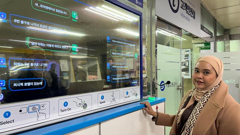 El 12 de diciembre, Nina Amila, de Malasia, prueba el sistema de interpretación simultánea en idiomas extranjeros en la estación de Myeongdong. 