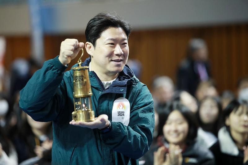 Jin Jongoh, presidente del comité organizador de Gangwon 2024, porta la antorcha olímpica el 28 de noviembre como parte de la gira de la antorcha para Gangwon 2024 en la Escuela Secundaria Yukminkwan en la ciudad de Wonju, provincia de Gangwon-do. | Agencia de Noticias Yonhap
