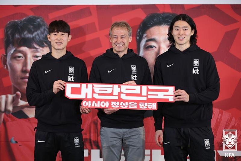 Jürgen Klinsmann, director técnico del equipo masculino de fútbol de Corea del Sur (centro), posa para una foto, el 28 de diciembre, junto al centrocampista Lee Jae-sung (izda.) y el delantero Cho Gue-sung durante una conferencia de prensa en Seúl para anunciar el equipo de 26 integrantes para la Copa Asiática de la AFC.