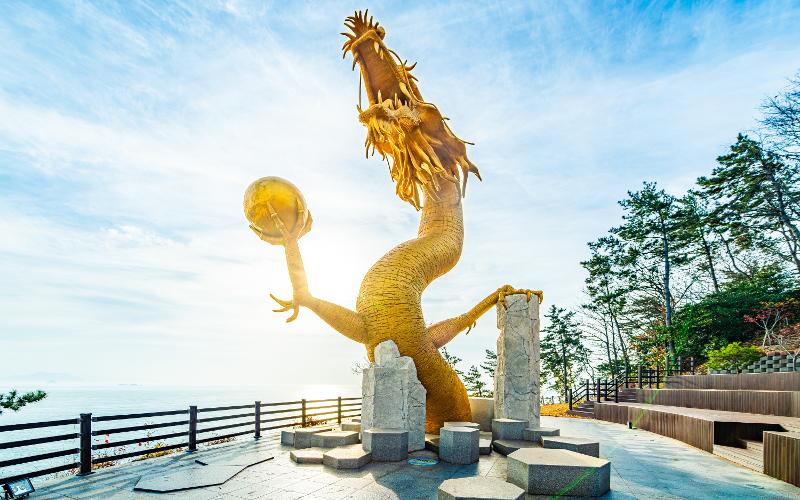  La foto muestra la escultura de un dragón que sostiene la joya chintámani, una piedra mítica con capacidad para conceder deseos a quien la porta, instalada en el sendero Mireumaru-gil, ubicado en el condado de Goheung-gun, en la provincia de Jeollanam-do. | Organización de Turismo de Corea 